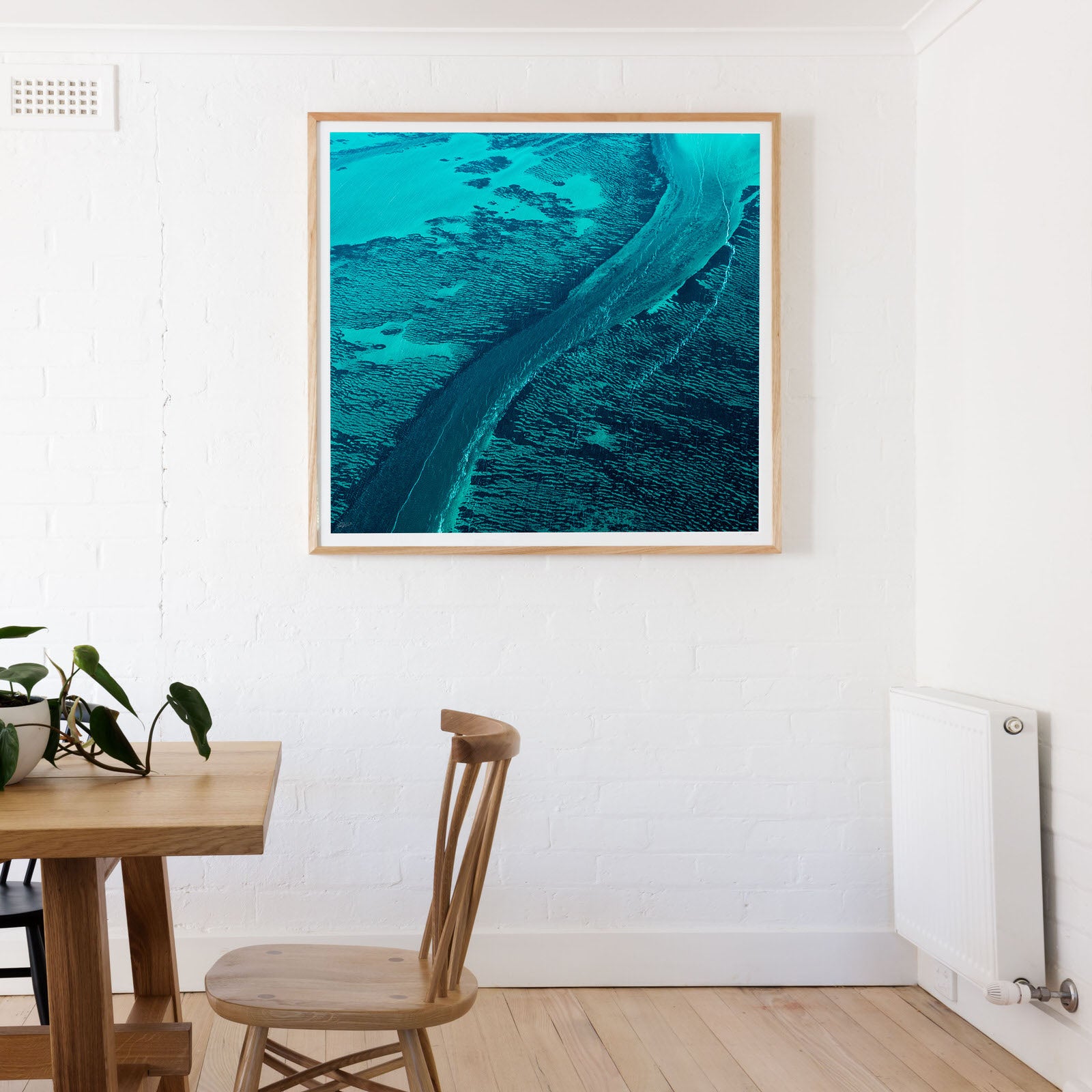 Square frame with abstract art print in blue and green near table