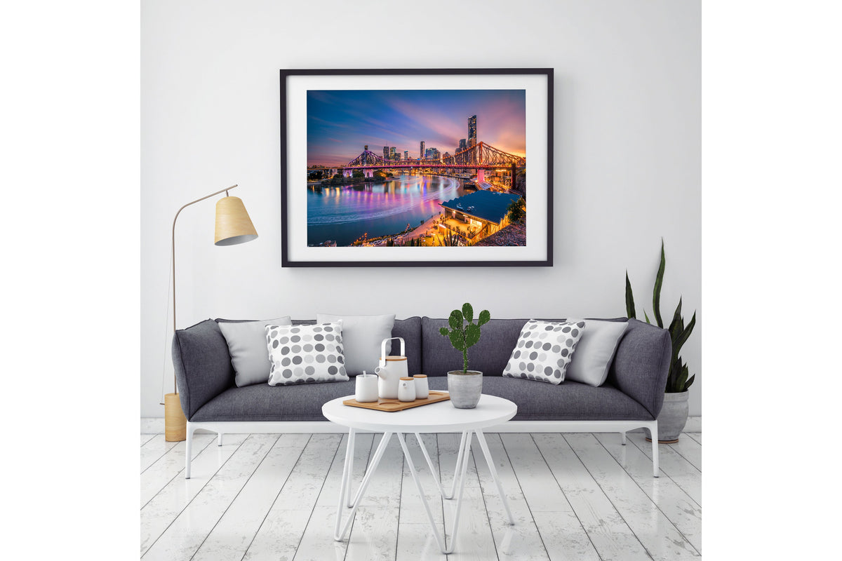 Brisbane's Story Bridge at sunset, the steel cantilever span lit gold against a coloured sky above the river, a fine art print by Jon Wright.