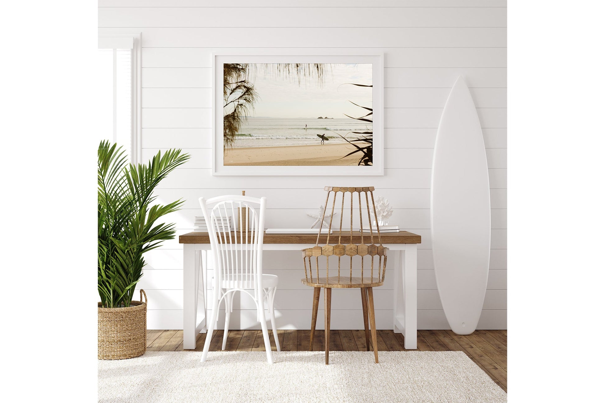 Byron Bay pastel surf print shown framed in white beside a surfboard in a coastal room.