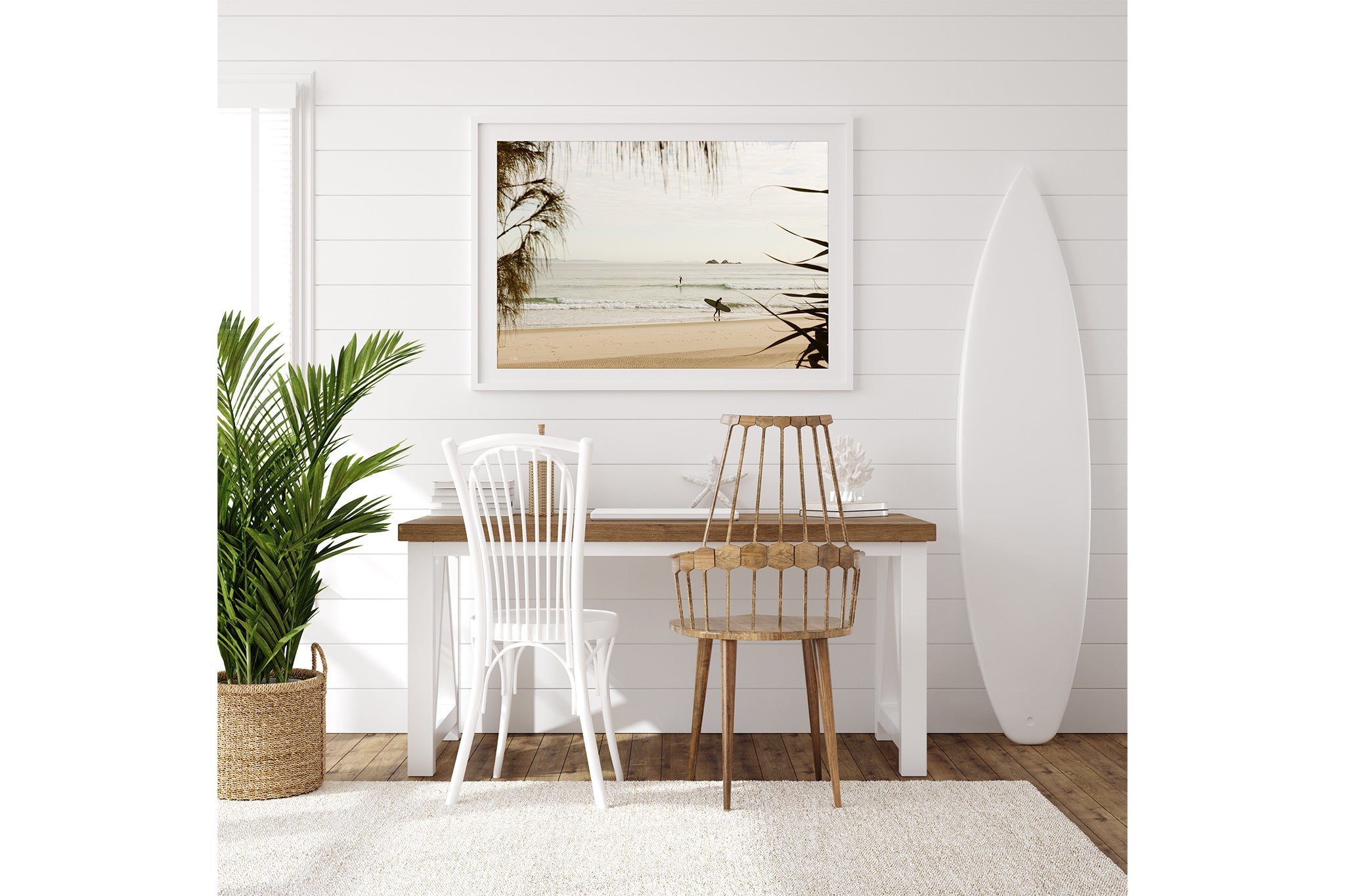 Byron Bay pastel surf print shown framed in white beside a surfboard in a coastal room.