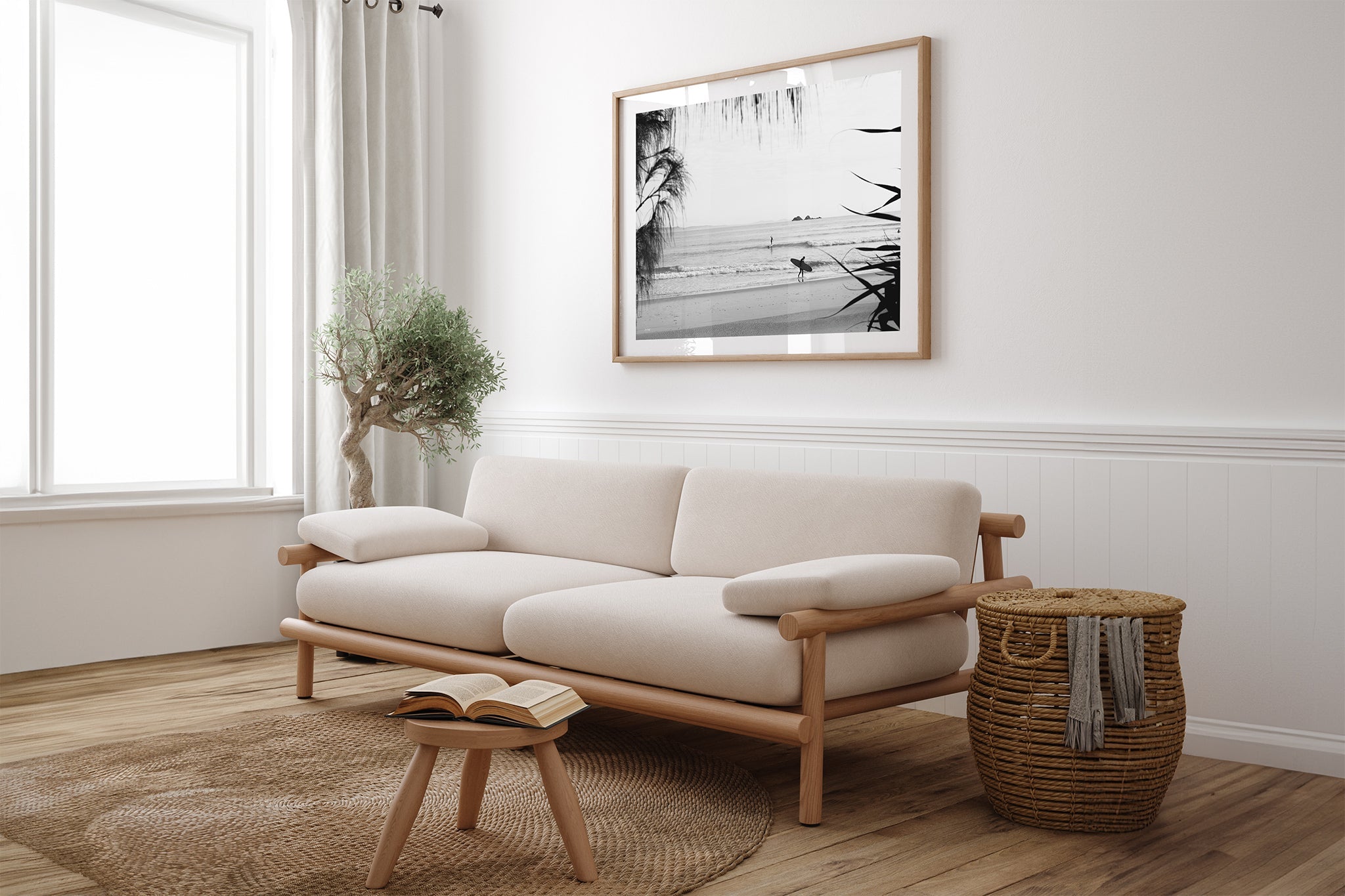 Byron Bay black and white surf print shown framed in oak above a linen couch.