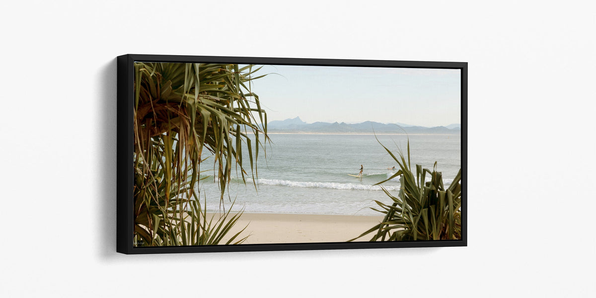 Byron Bay panoramic surf print shown as a black float frame canvas.