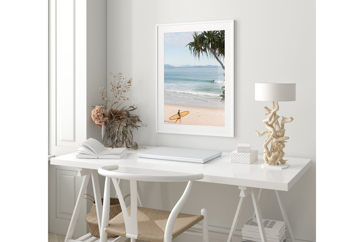 Yellow longboard Byron Bay print shown framed in white in a coastal styled room.