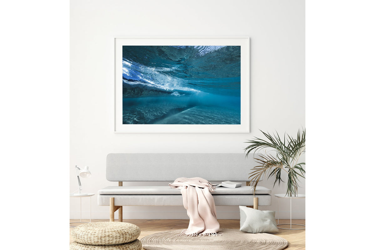 Quiet Shallows print shown framed in white above a bench seat.