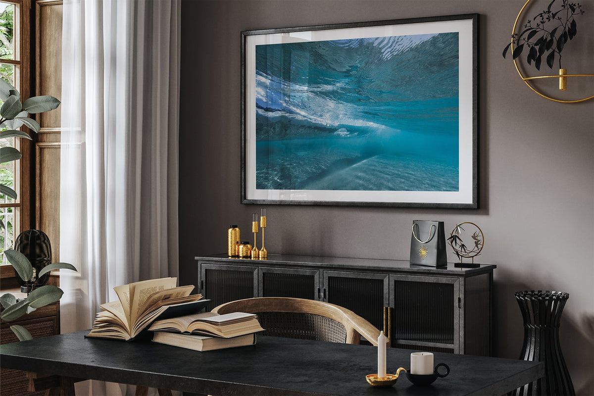 Quiet Shallows print shown framed in black in a dark room.