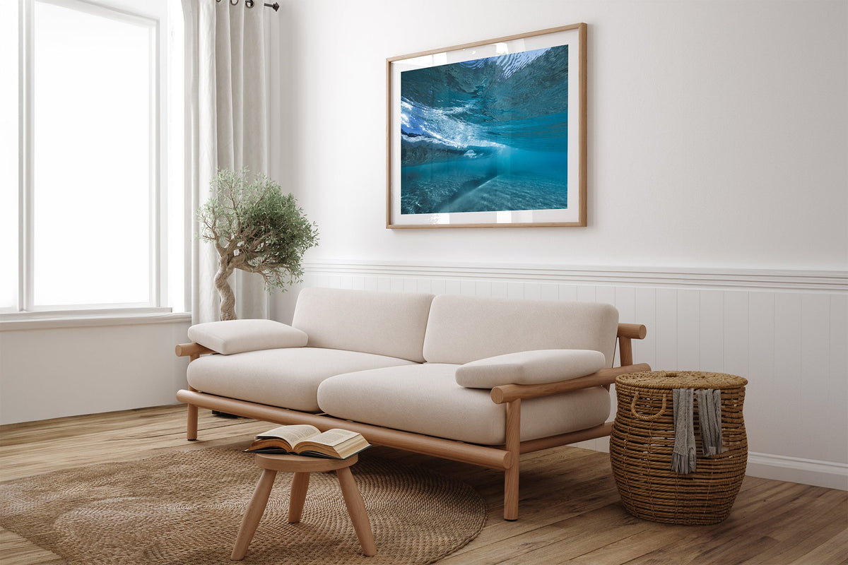 Quiet Shallows print shown framed in oak above a linen couch.