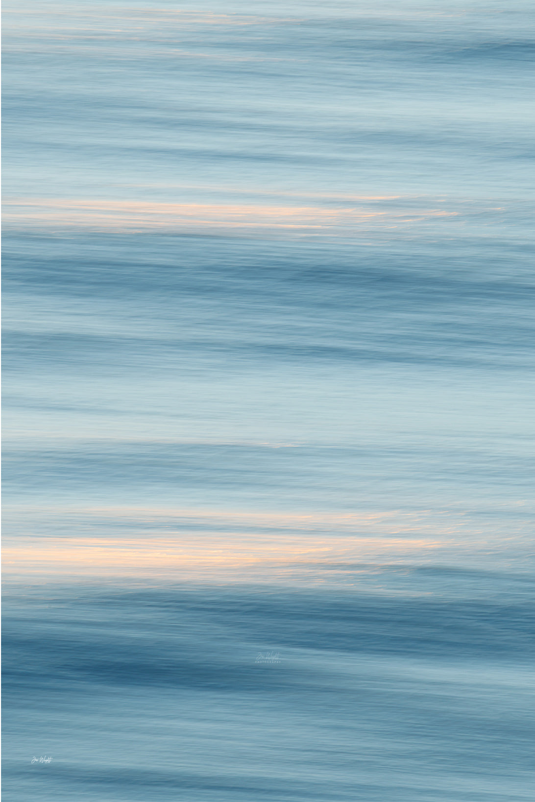Soft sky blue and slate bands of blurred water with two thin streaks of peach light, a calm slow shutter abstract print.