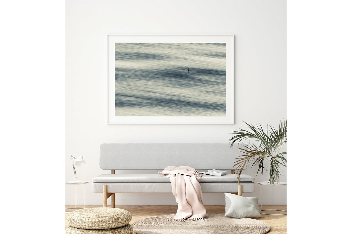 Lone Gull print shown framed in white above a bench seat.