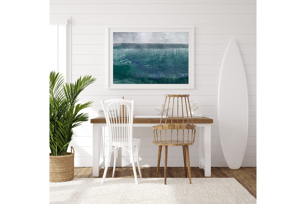 Jade Veil print shown framed in white on a white shiplap wall with a surfboard leaning beside a desk.