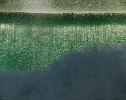 A wave wall of bright green water under a band of white spray, fading to dark slate at the bottom, an abstract ocean wall print.