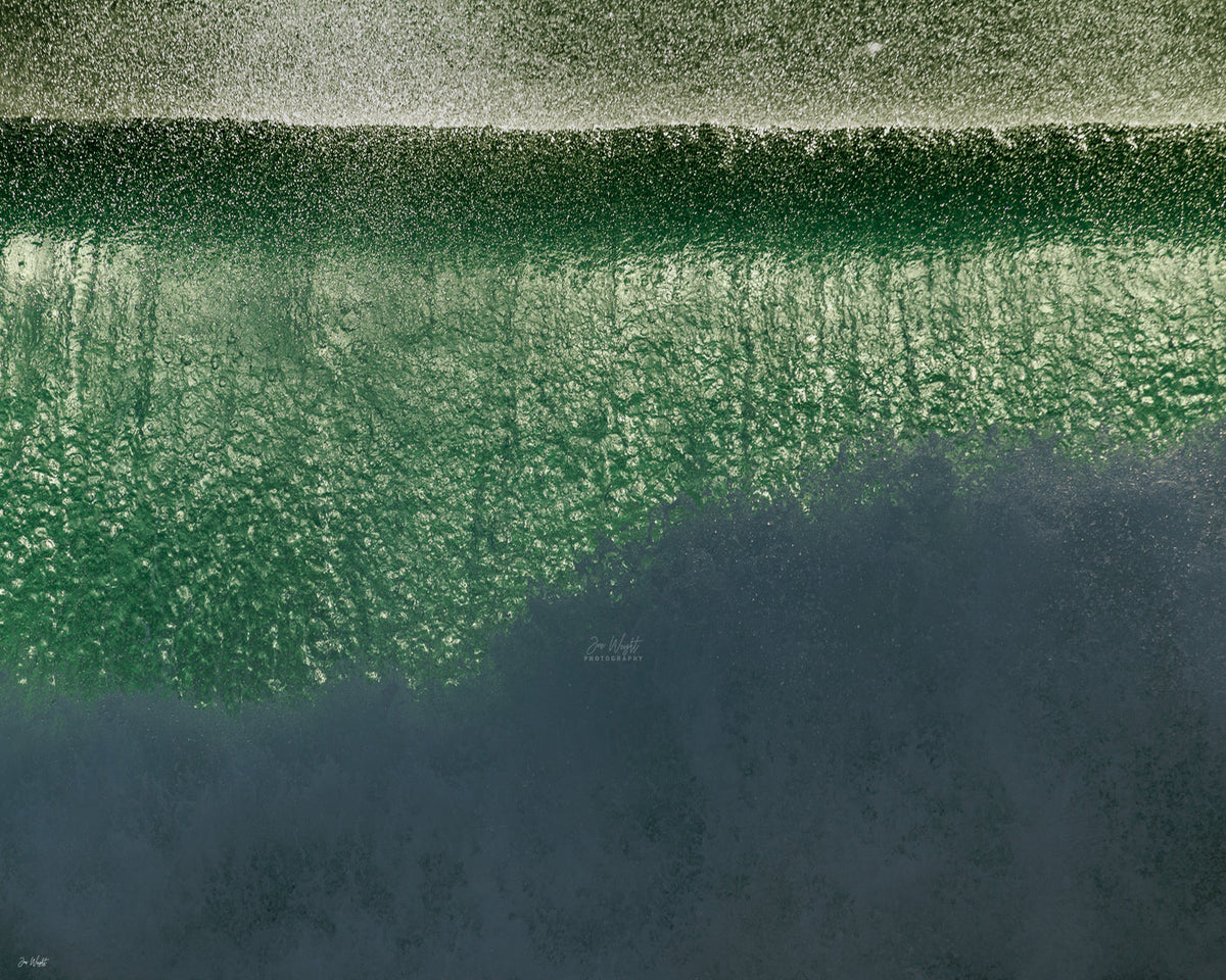 A wave wall of bright green water under a band of white spray, fading to dark slate at the bottom, an abstract ocean wall print.