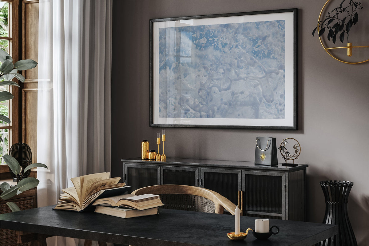 Frozen Splash print shown framed in black in a dark room.