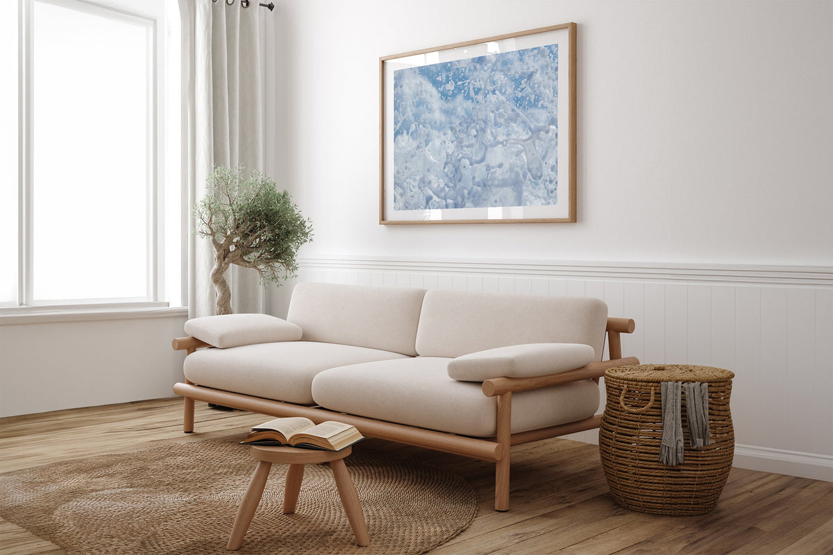 Frozen Splash print shown framed in oak above a linen couch.