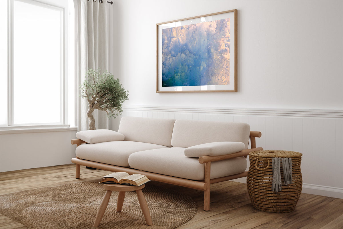 Coral Marble print shown framed in oak above a linen couch.