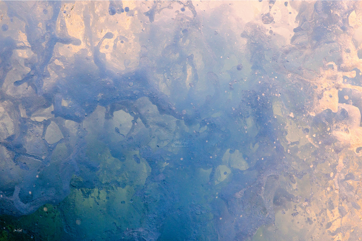 Marbled sea foam in blue, green and slate with a soft peach glow on the right side, an abstract ocean wall print.