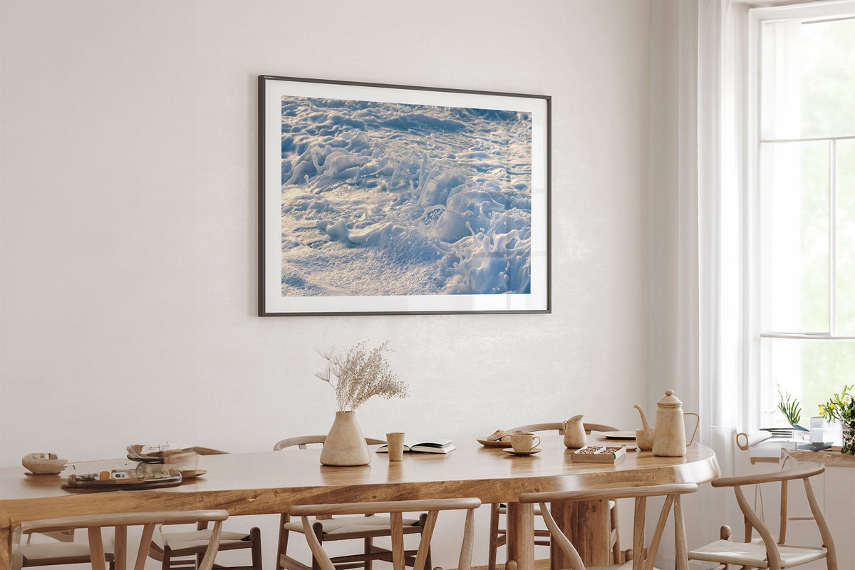 Frost Foam print shown framed in black above an oak table.