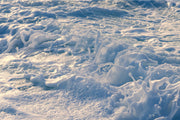 Sculpted white sea foam with cool blue shadows and a touch of warm gold light on the left, an abstract ocean wall print.