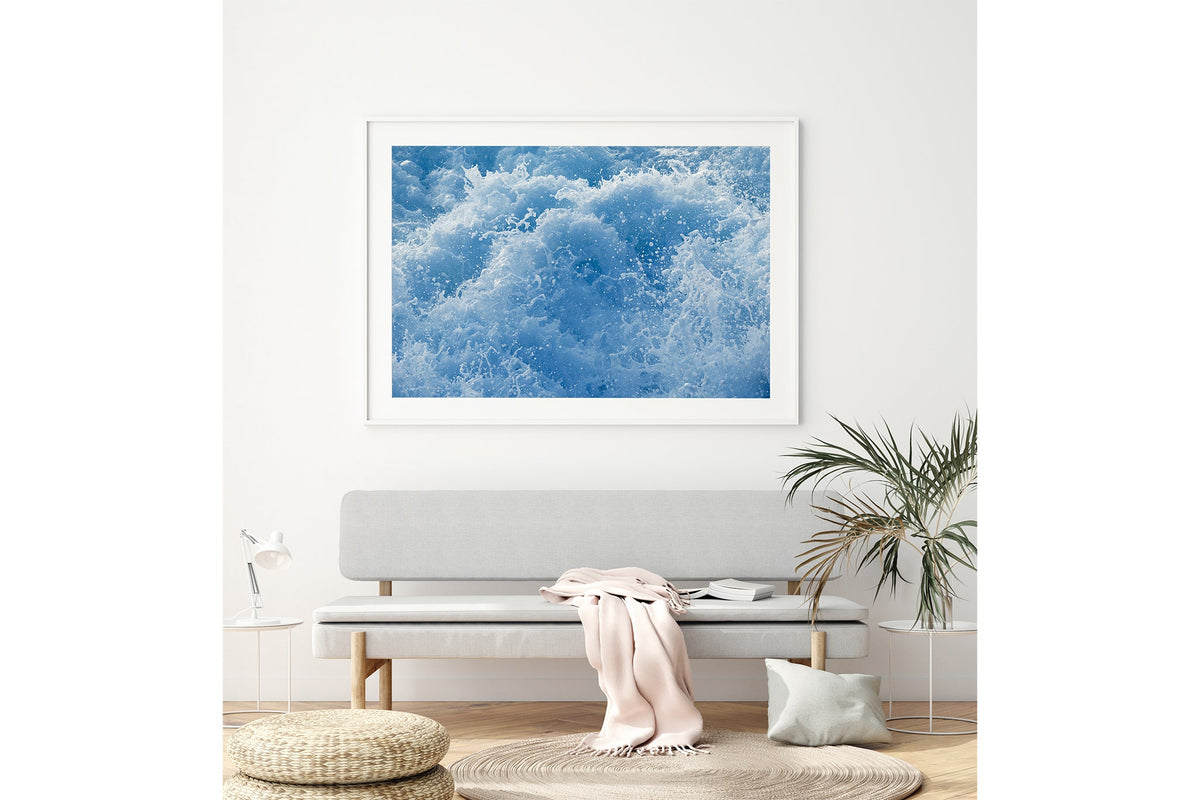 Cobalt Chaos print shown framed in white above a bench seat.