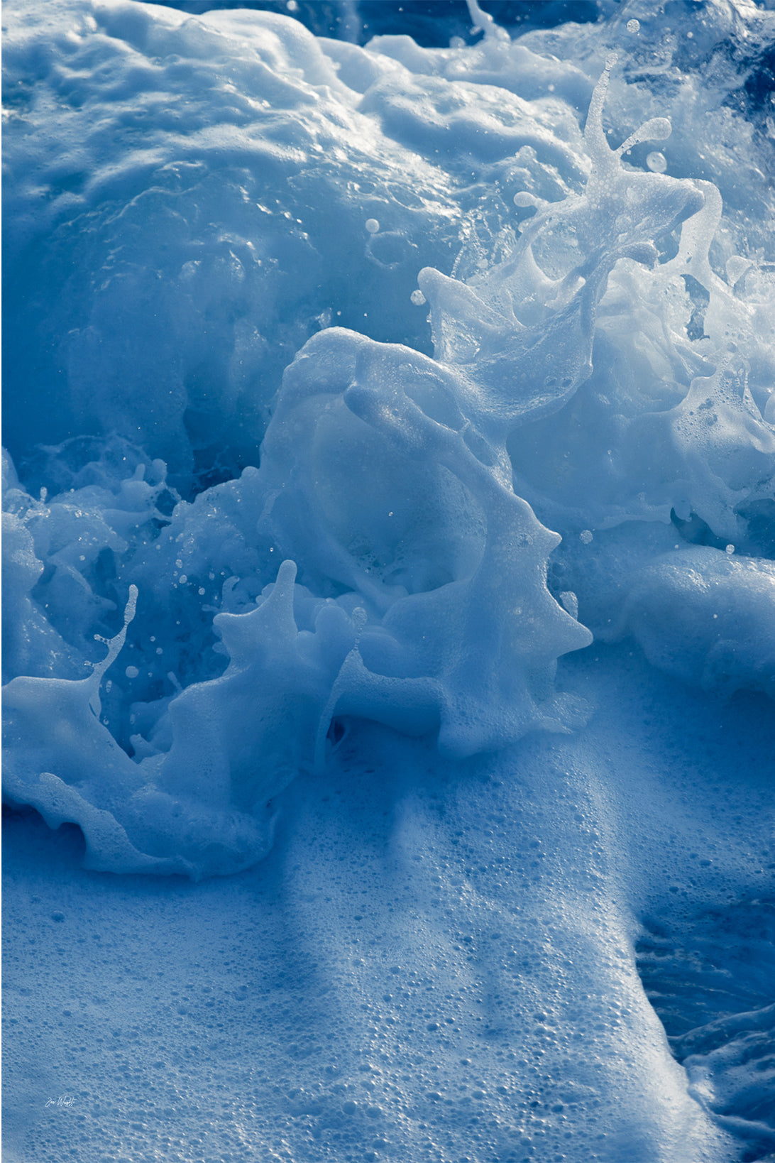 Sculpted white and ice blue sea foam folding and splashing over deeper blue water, an abstract ocean wall print.