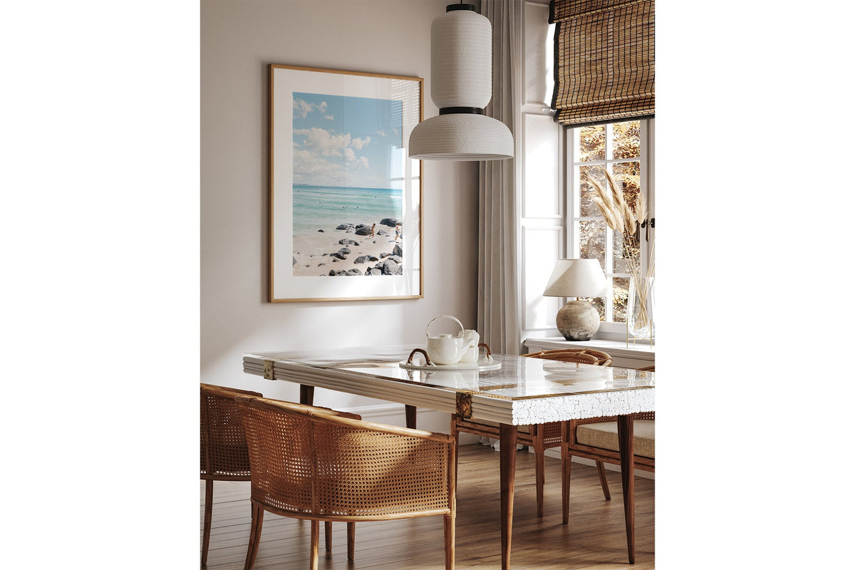 Rocky Shore Skyline print shown framed in oak above a dining table.