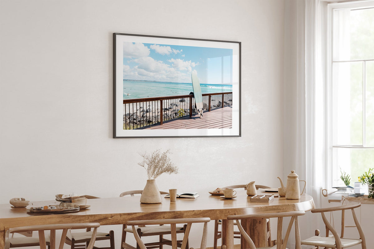Boardwalk Break print shown framed in black above an oak table.