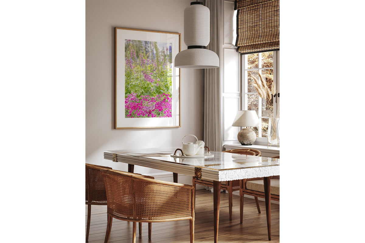 Foxglove garden print shown framed in oak above a dining table.