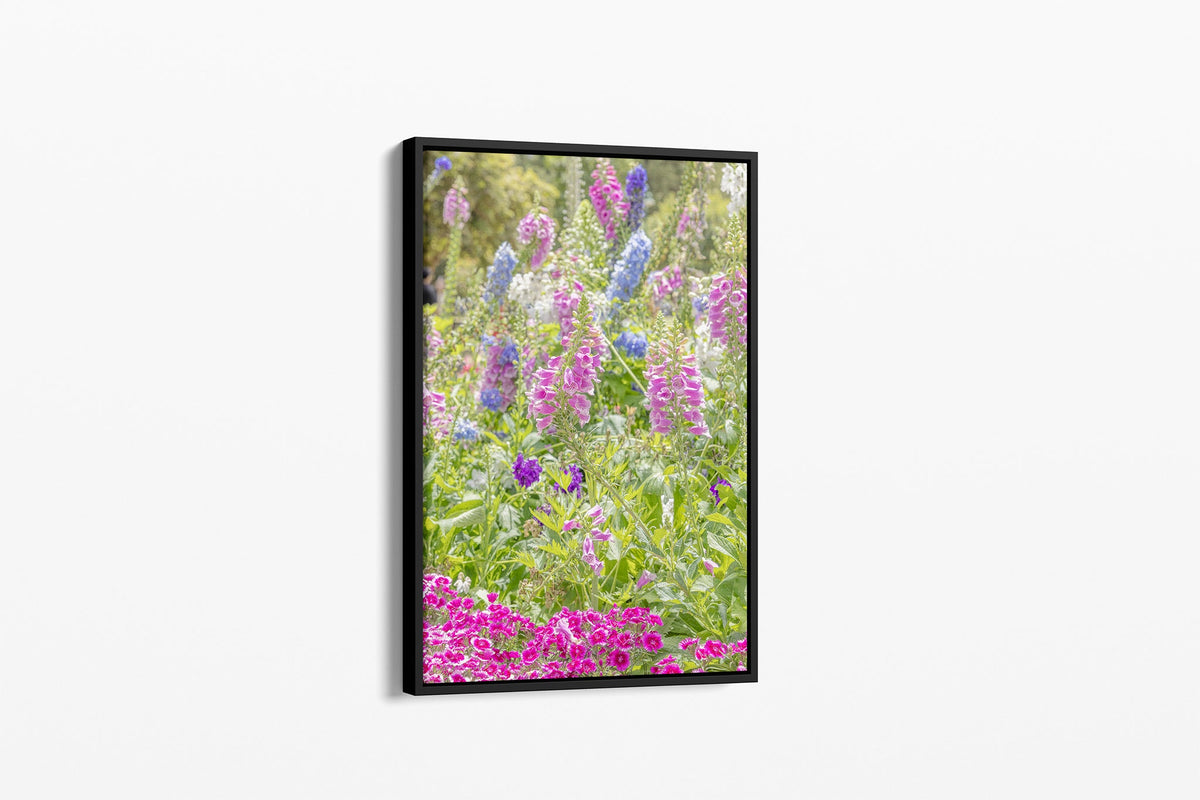 Cottage garden floral print shown as a canvas in a black float frame.