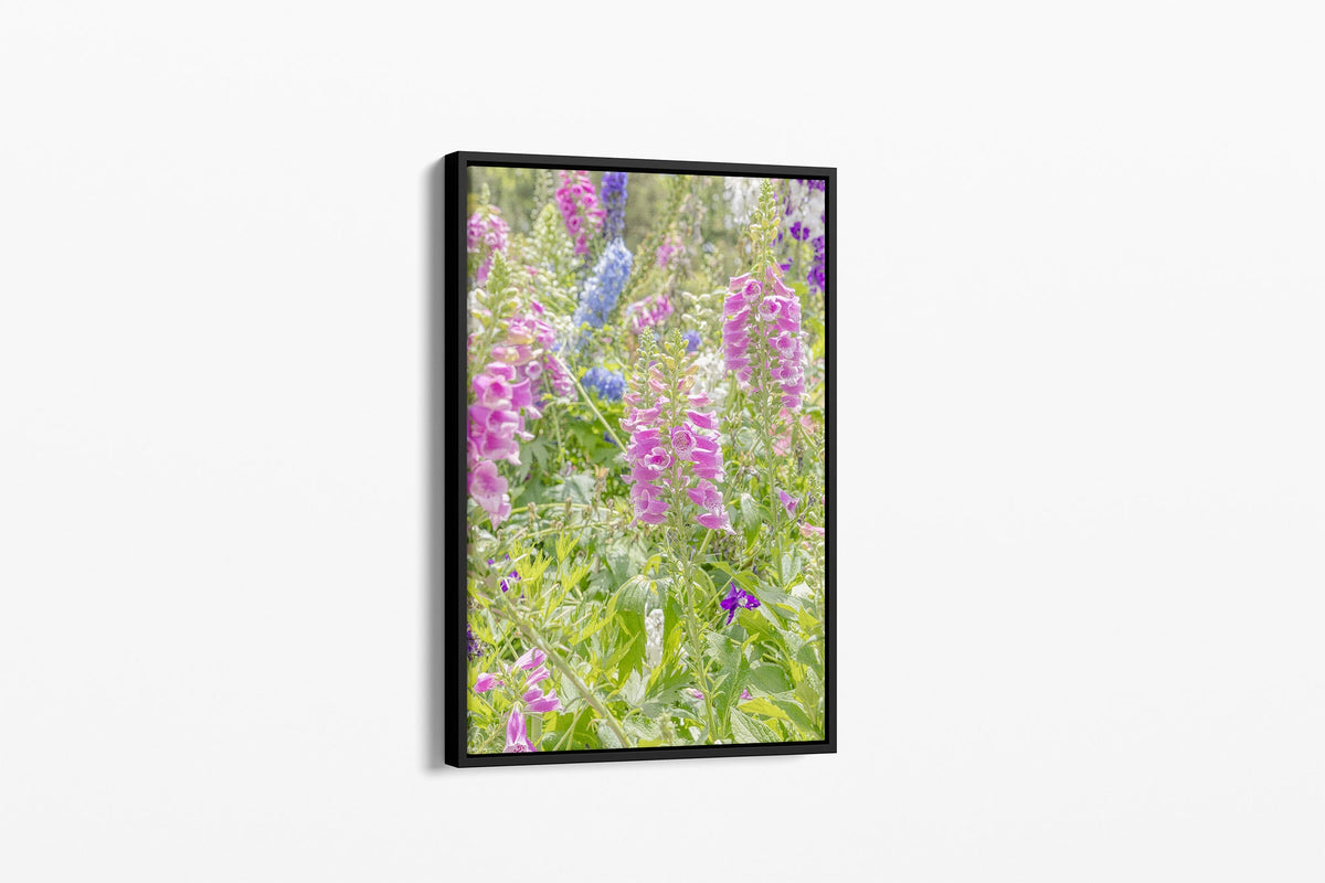 Foxglove and delphinium print shown as a canvas in a black float frame.