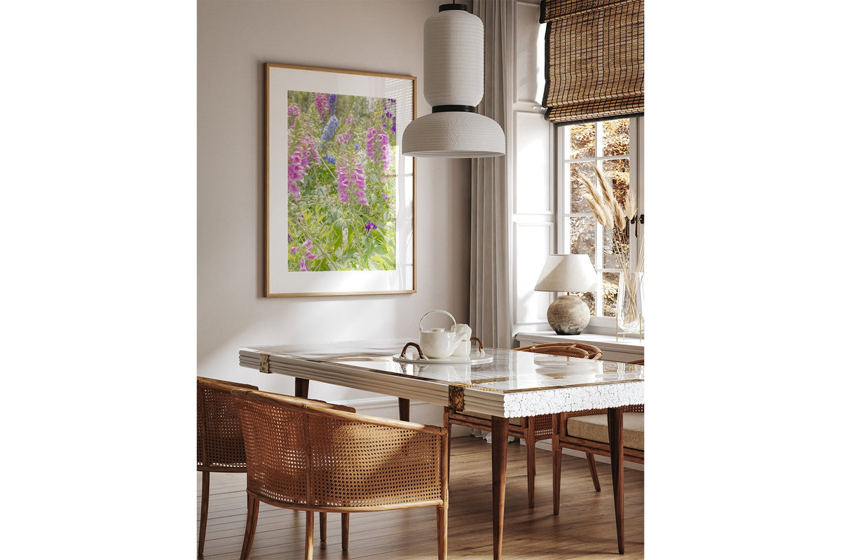 Foxglove and delphinium print shown framed in oak above a dining table.