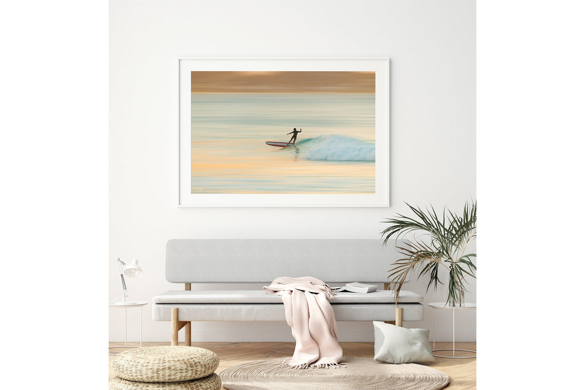 Longboard surfer print shown framed in white above a bench seat.