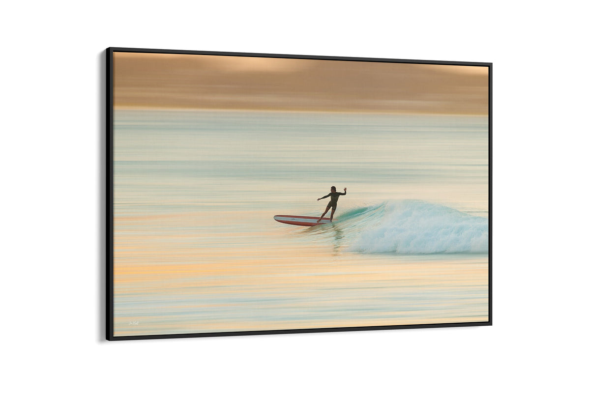 Longboard surfer print shown as a canvas in a black float frame.
