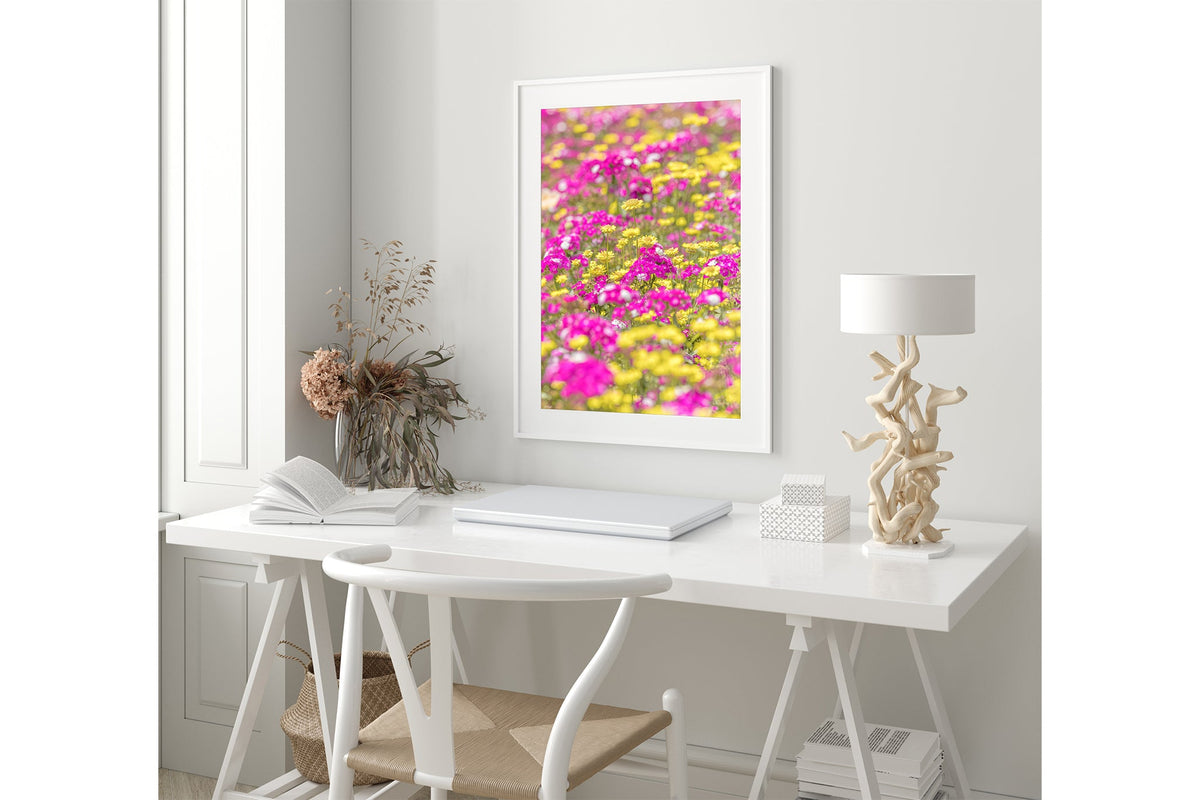 Pink and yellow meadow print shown framed in white.