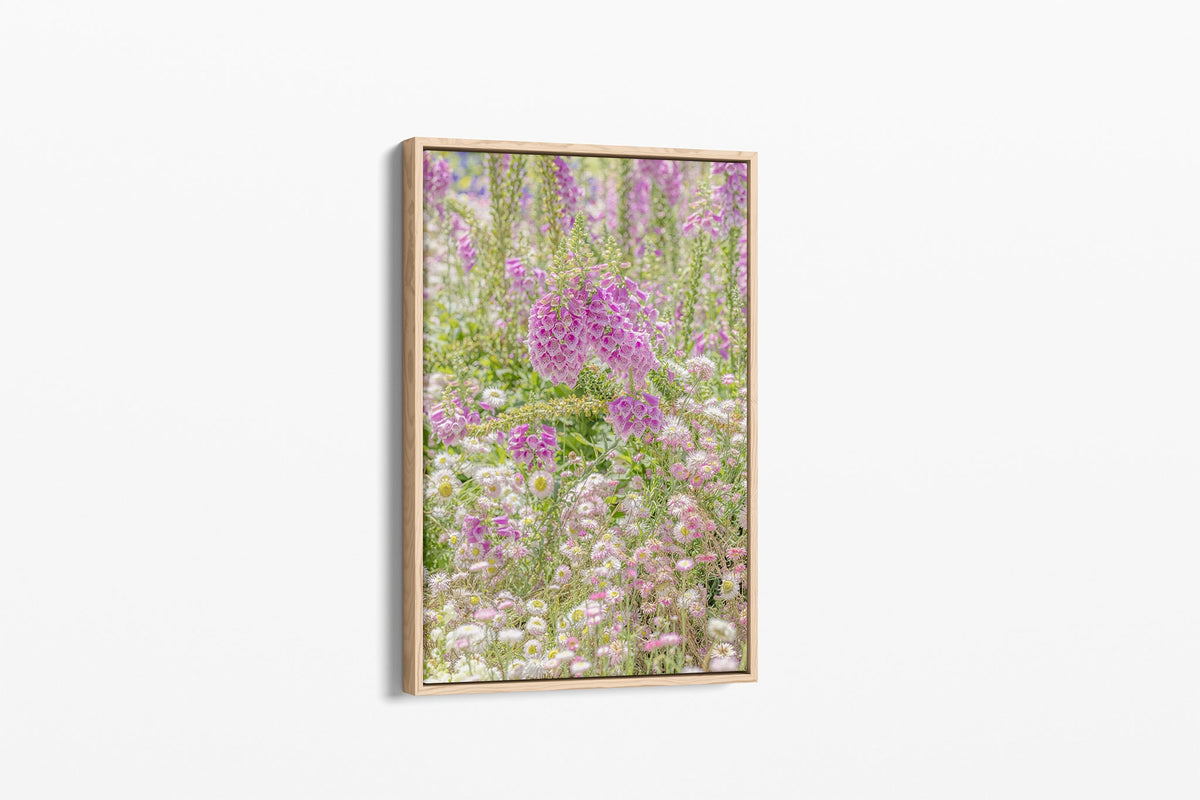 Foxglove meadow print shown as a canvas in an oak float frame.