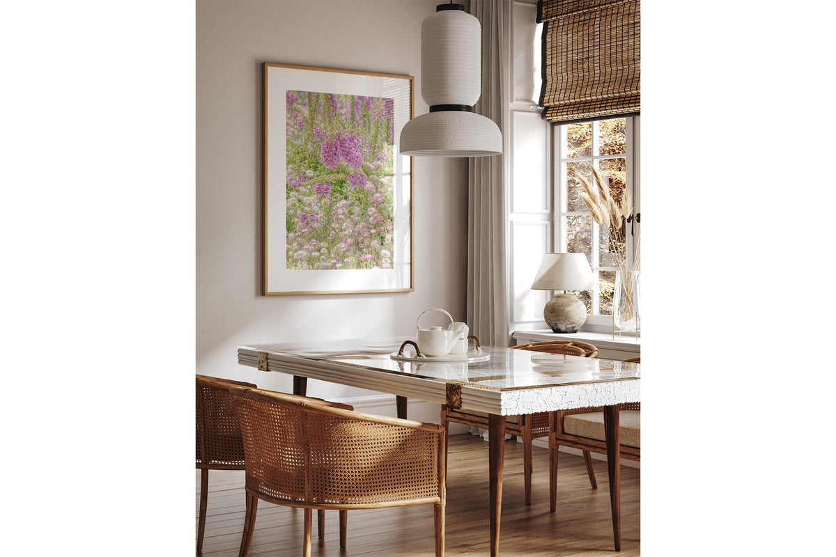 Foxglove meadow print shown framed in oak above a dining table.
