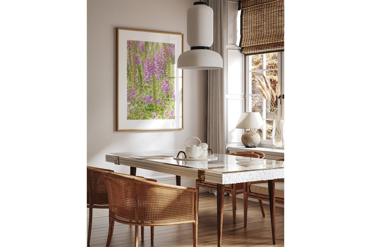 Lilac foxglove print shown framed in oak above a dining table.