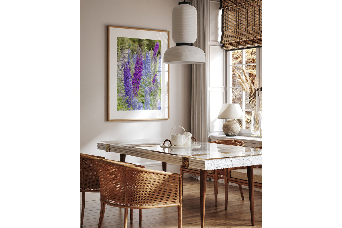 Delphinium print shown framed in oak above a dining table.