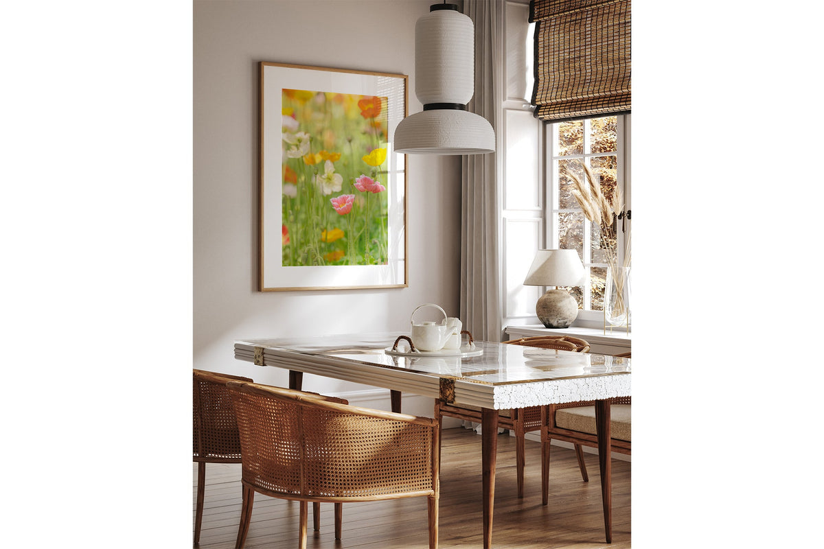 Soft poppy print shown framed in oak above a dining table.
