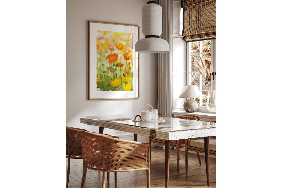 Orange poppy print shown framed in oak above a dining table.