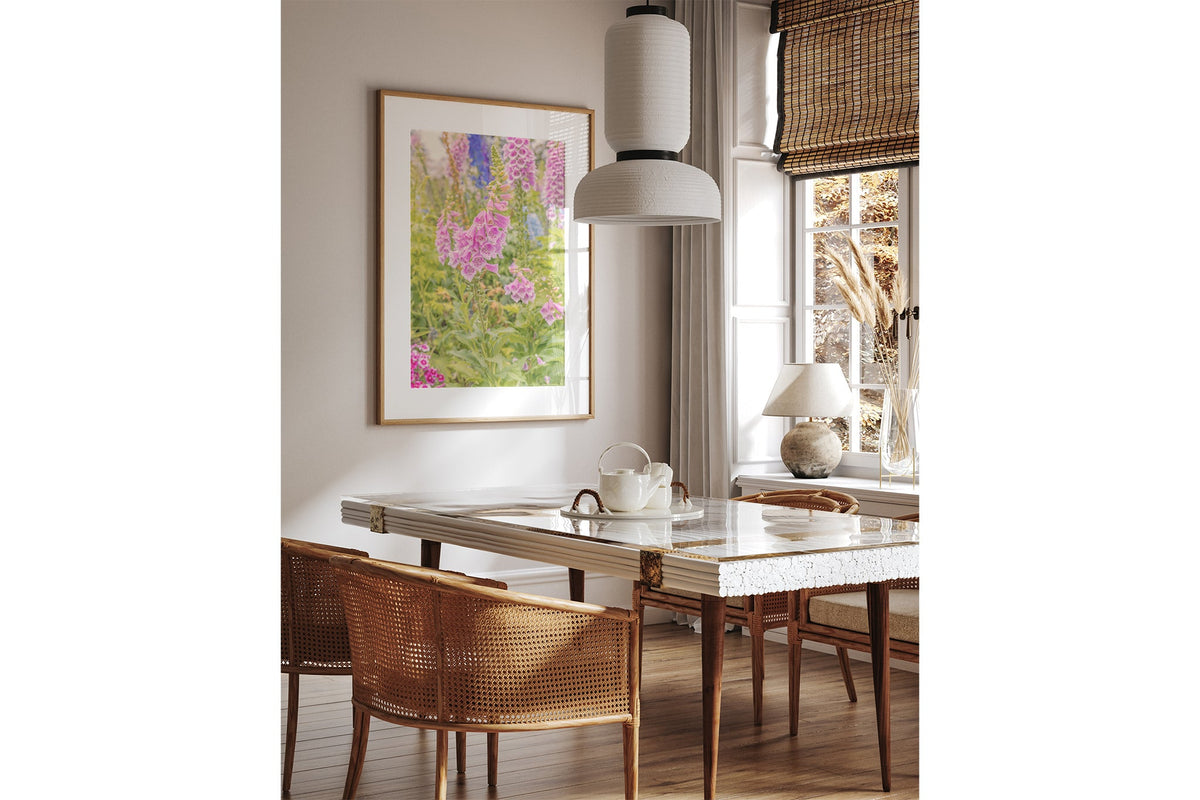Foxglove light print shown framed in oak above a dining table.