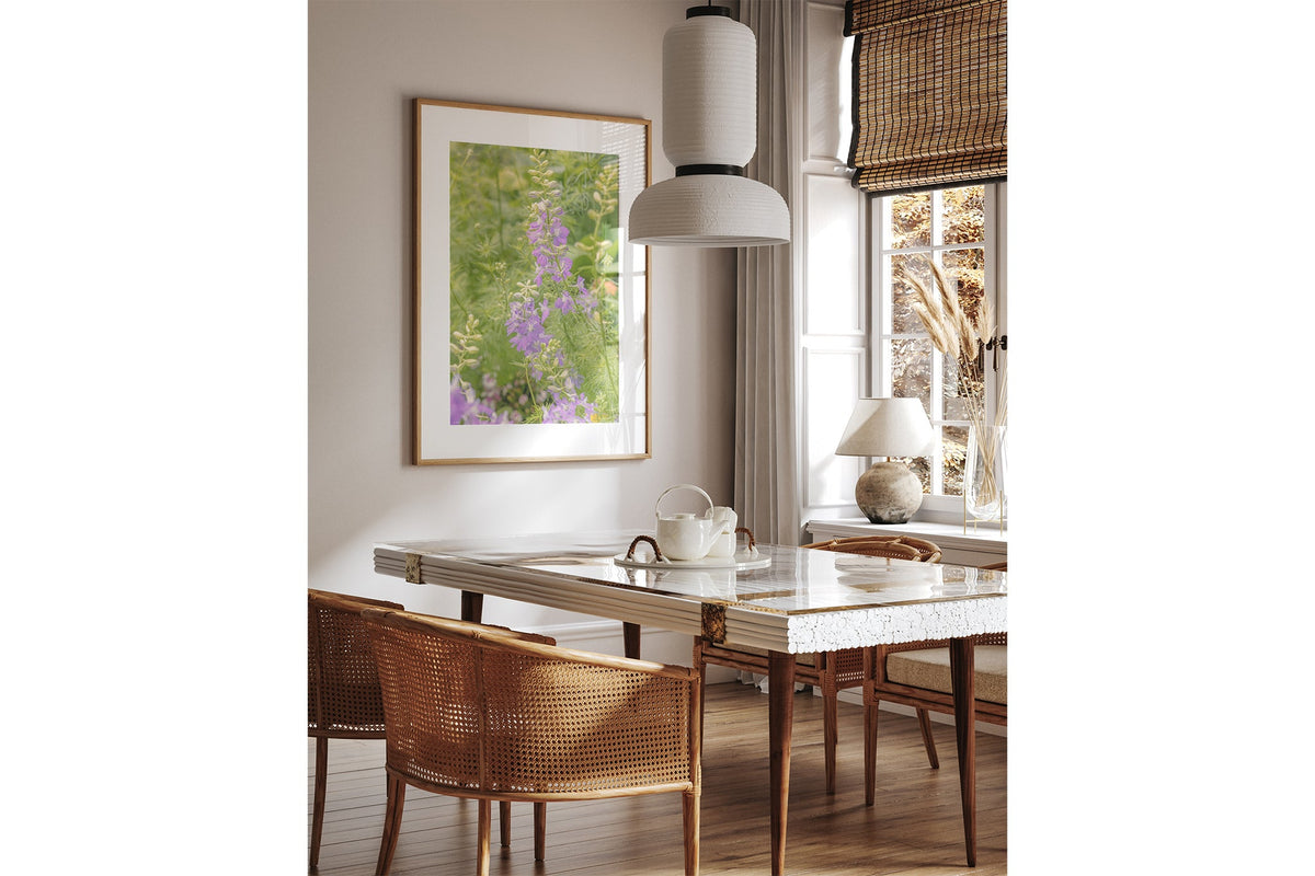Lilac larkspur print shown framed in oak above a dining table.