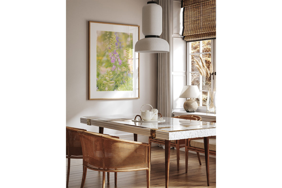 Glowing larkspur print shown framed in oak above a dining table.