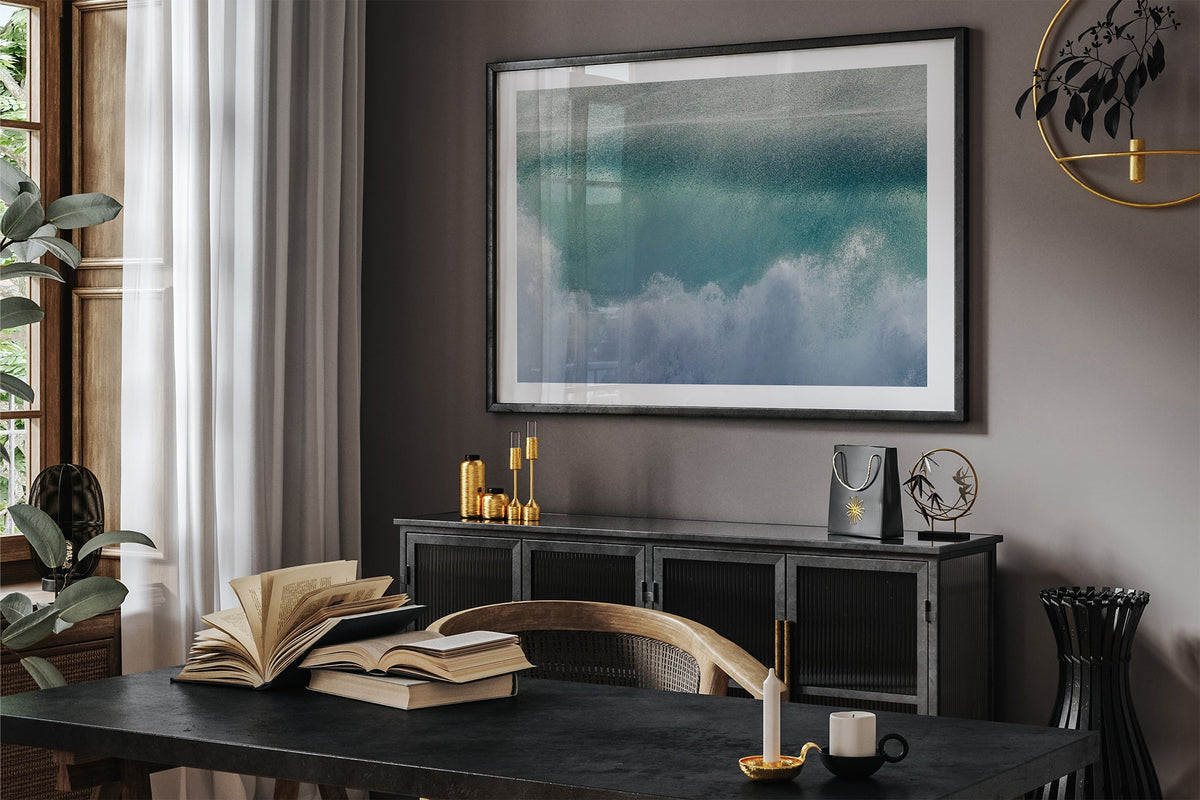 Aqua wave print shown framed in black in a dark room.