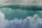 An abstract aqua and teal wave face dotted with fine spray above a surge of white foam, an ocean wall print.