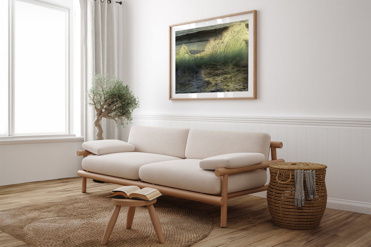 Emerald Crest print shown framed in oak above a linen couch.