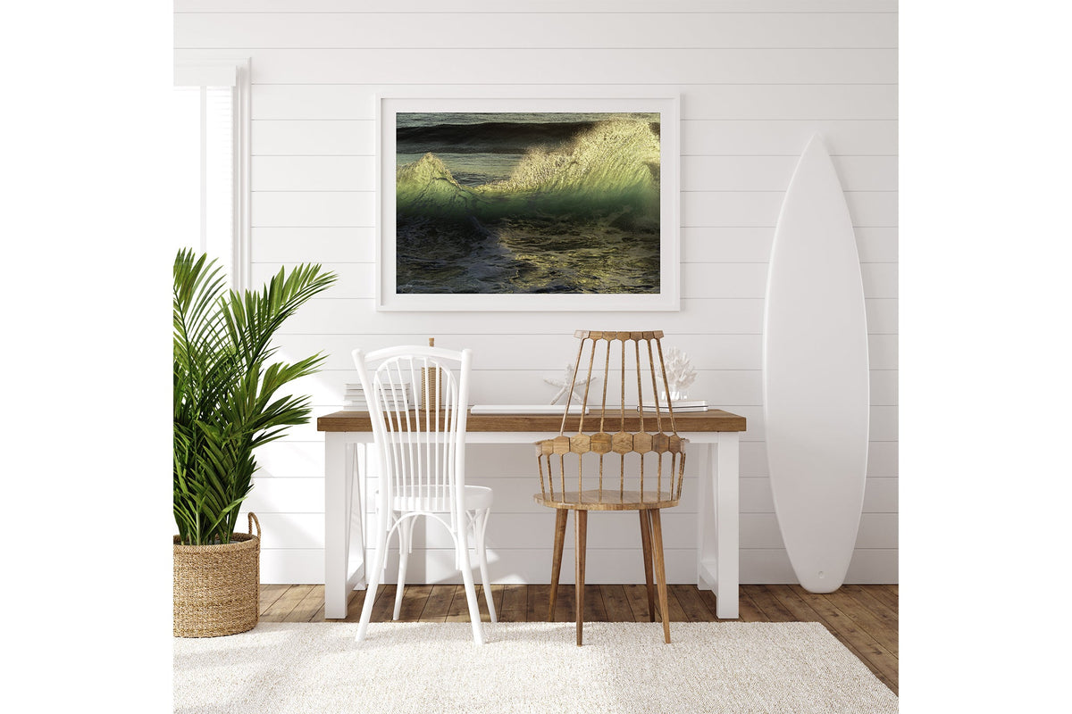 Emerald Crest print shown framed in white on a white shiplap wall with a surfboard leaning beside a desk.
