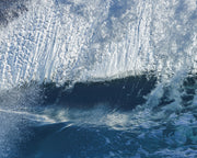 A crystalline wave face of white and pale blue water over a shadowed band of deep blue, an abstract ocean wall print.