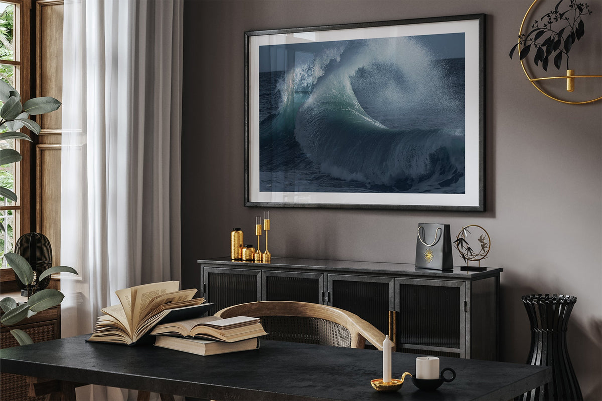Rising Surge print shown framed in black in a dark room.