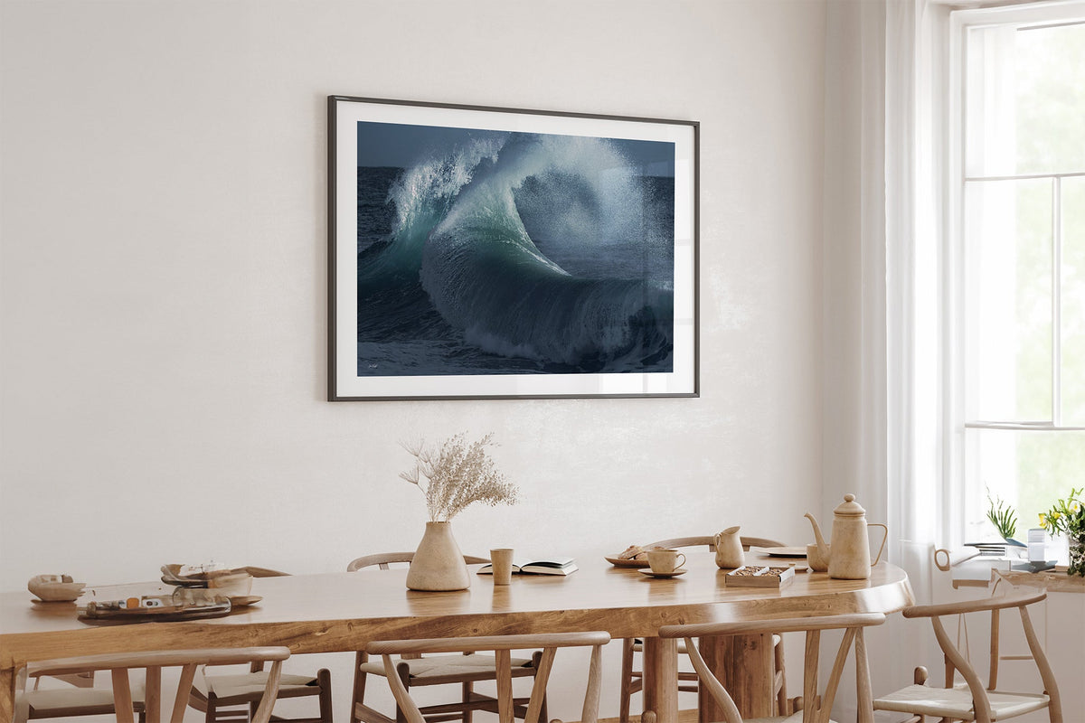 Rising Surge print shown framed in black above an oak table.