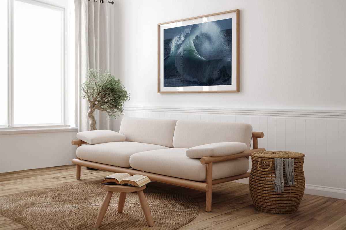 Rising Surge print shown framed in oak above a linen couch.