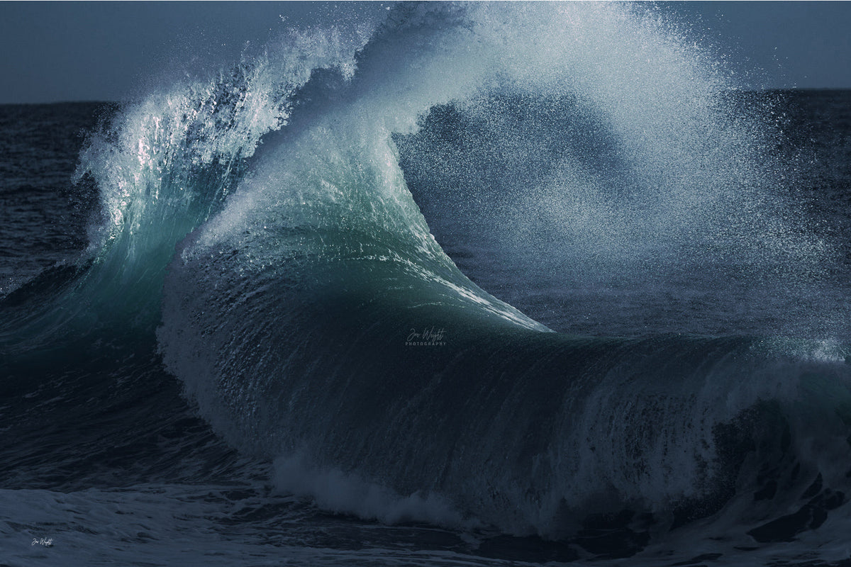A large teal wave curling beneath a cloud of fine white spray against dark navy water, a powerful ocean wall print.